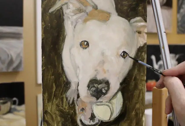 Reinforcing dark areas on a pet portrait painting of a pit bull.