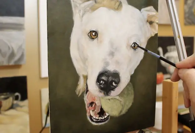 Adding details to the eyes on a pet portrait painting of a pit bull.